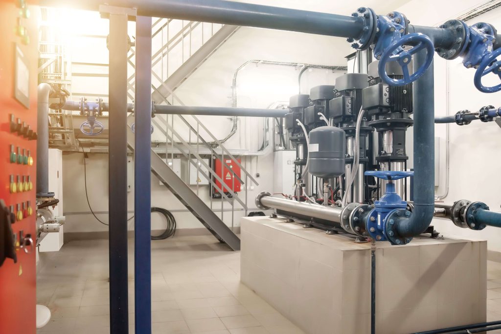 Industrial pump room with blue butterfly valves and piping system used for HVAC and water treatment flow control