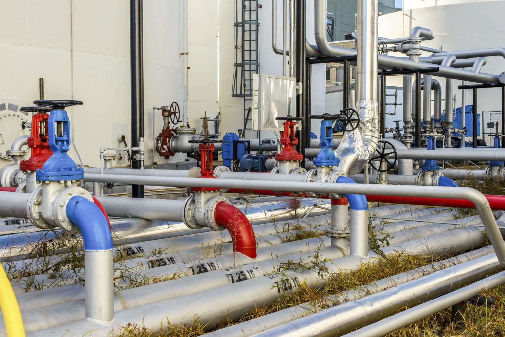 Industrial piping system with blue and red valves at a process facility