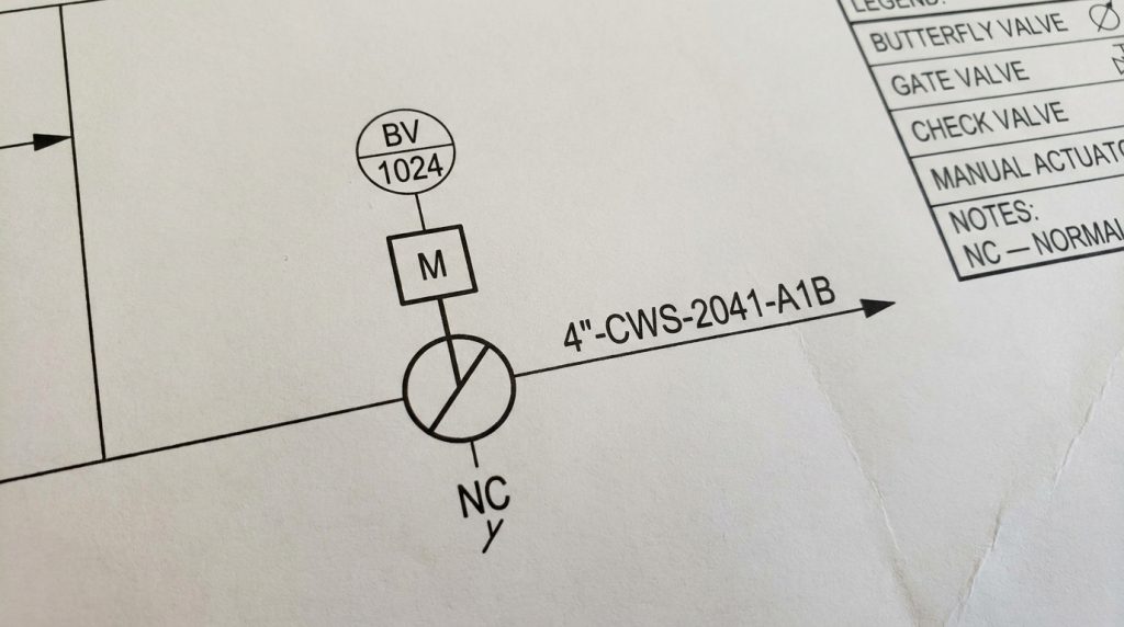 Close-up of a P&ID sheet showing a butterfly valve symbol with tag number, actuator note, and normal position label
